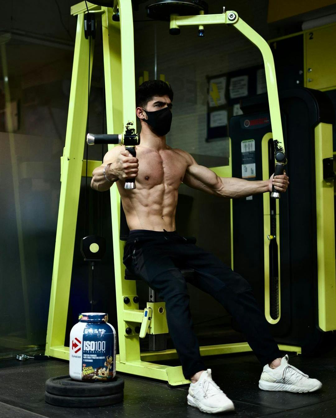 Dymatize Squad member on chest fly machine with ISO100 Whey Protein.