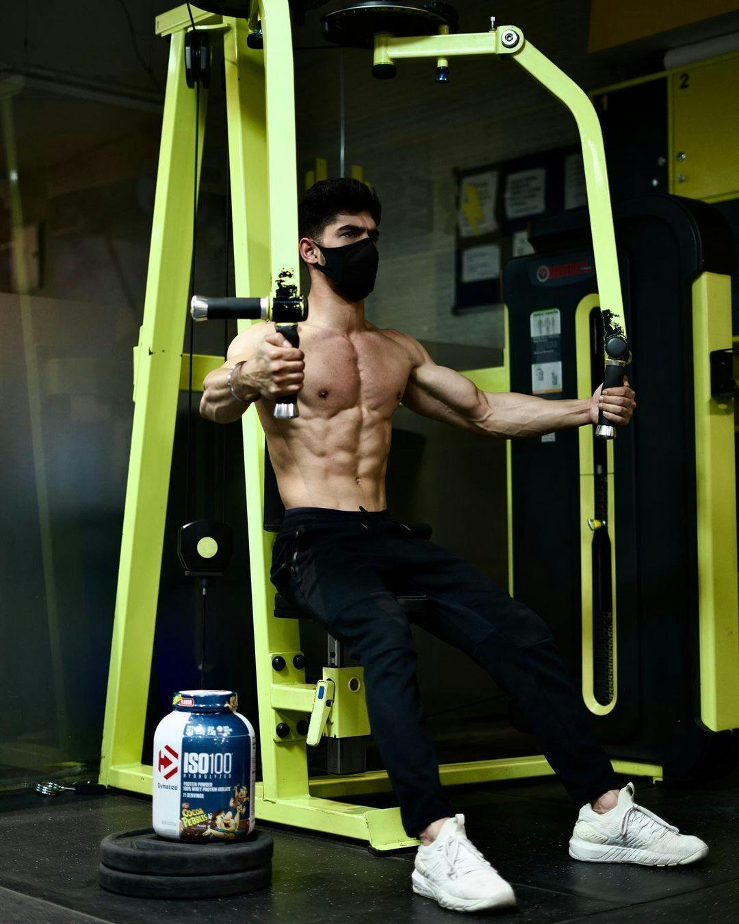 Dymatize Squad member on chest fly machine with ISO100 Whey Protein.