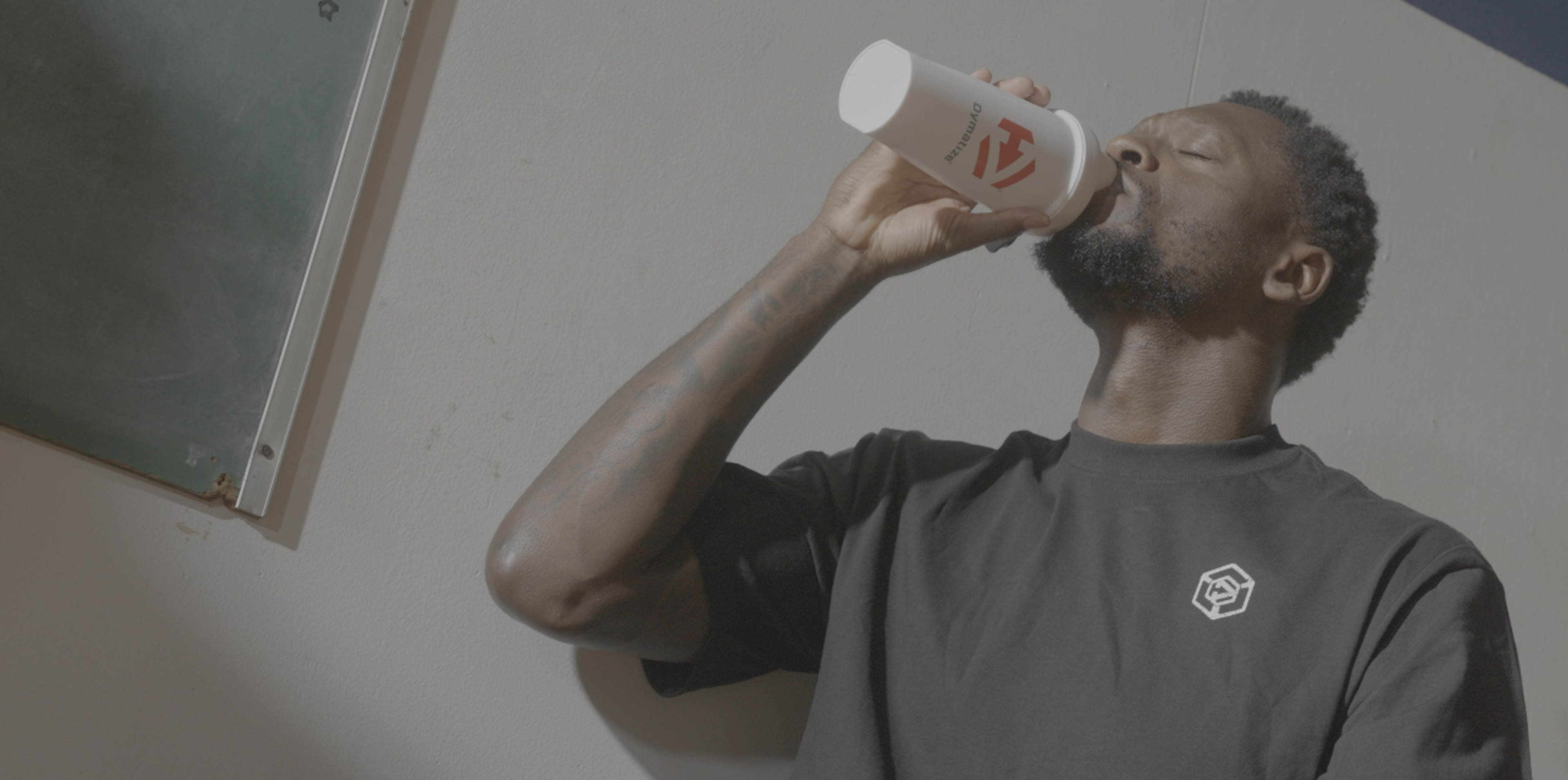 Julius Randle drinking Dymatize from a Dymatize bottle.