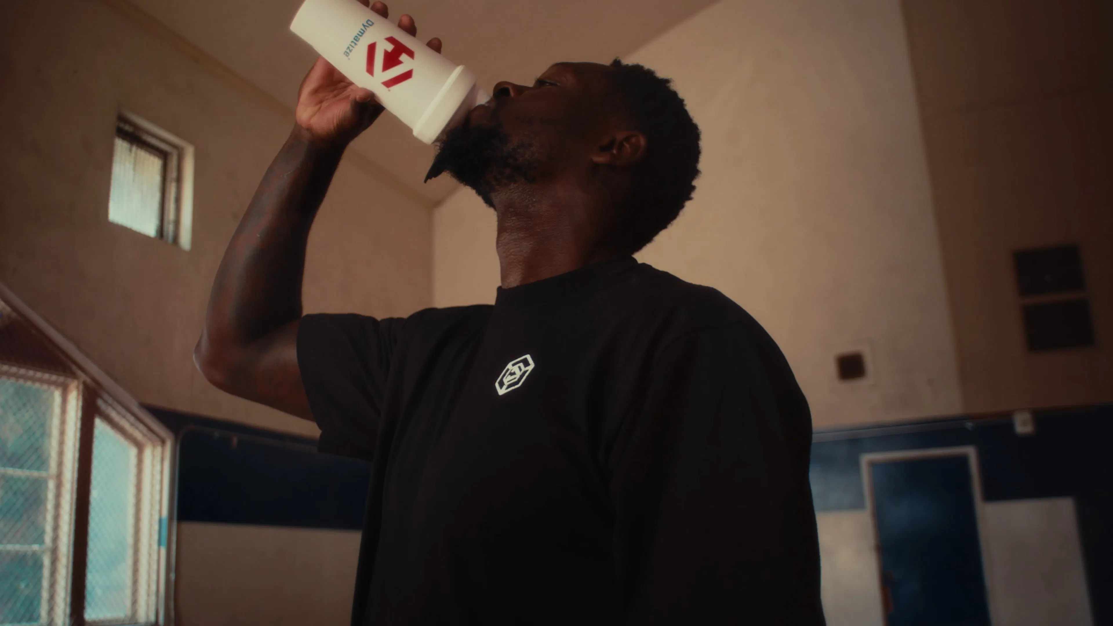 Julius Randle drinking Dymatize from a Dymatize bottle.