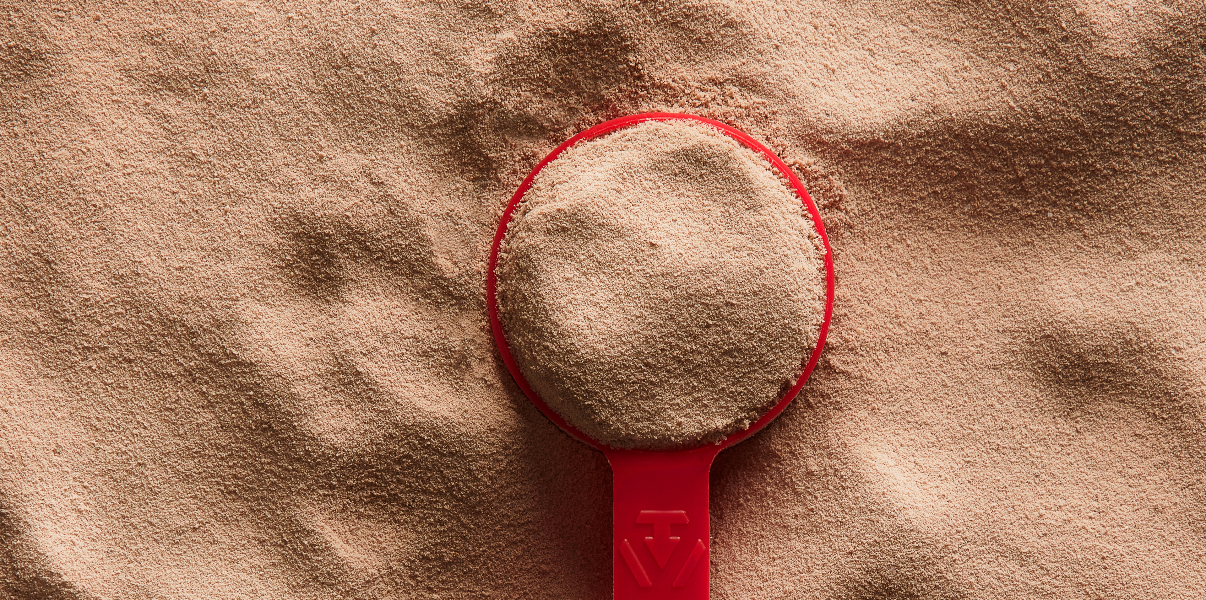 A measuring spoon sitting on top of a mound of Dymatize ISO100 Powder.