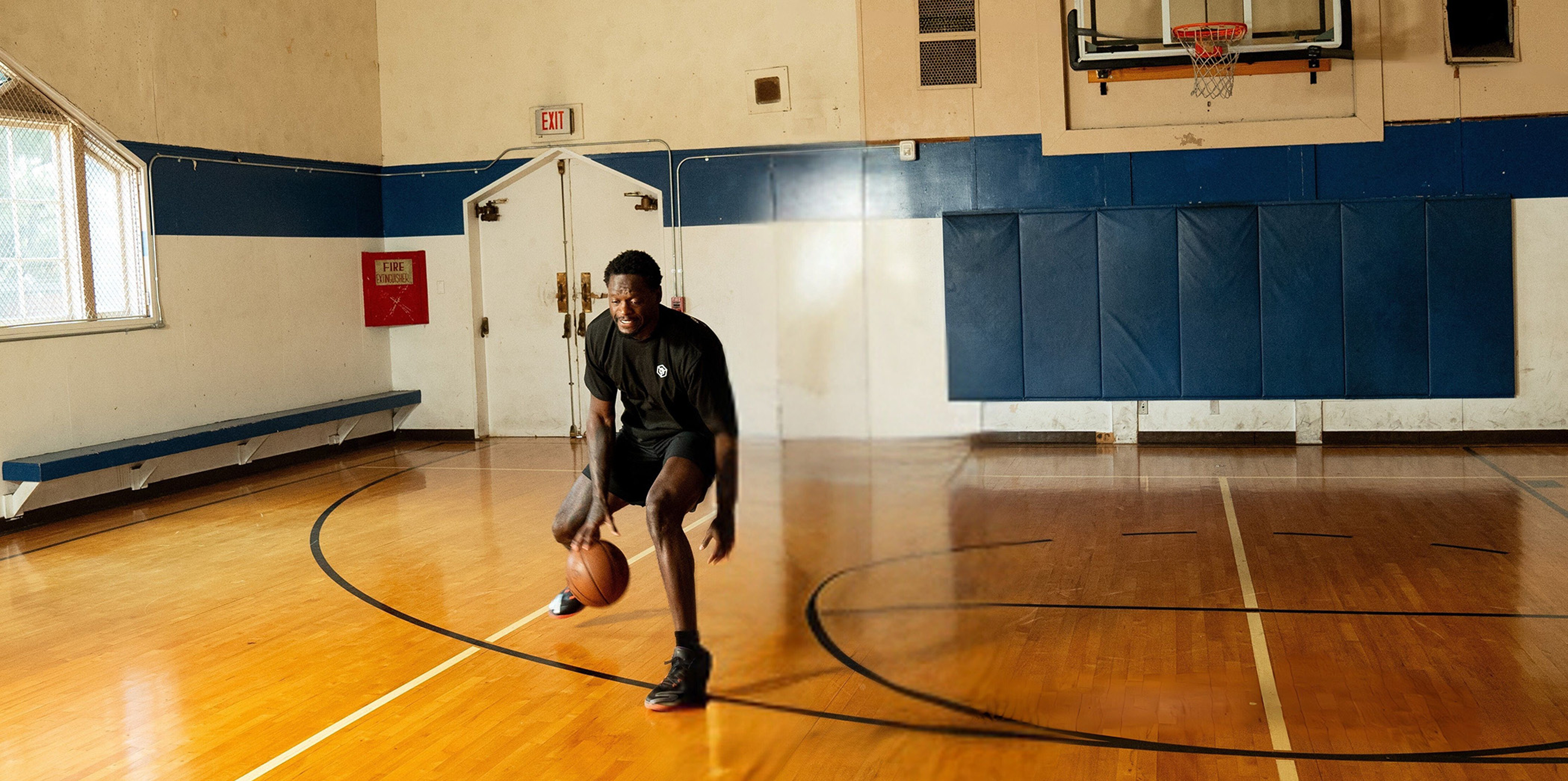 Julius Randle dribbling a basketball in an indoor basketball court.
